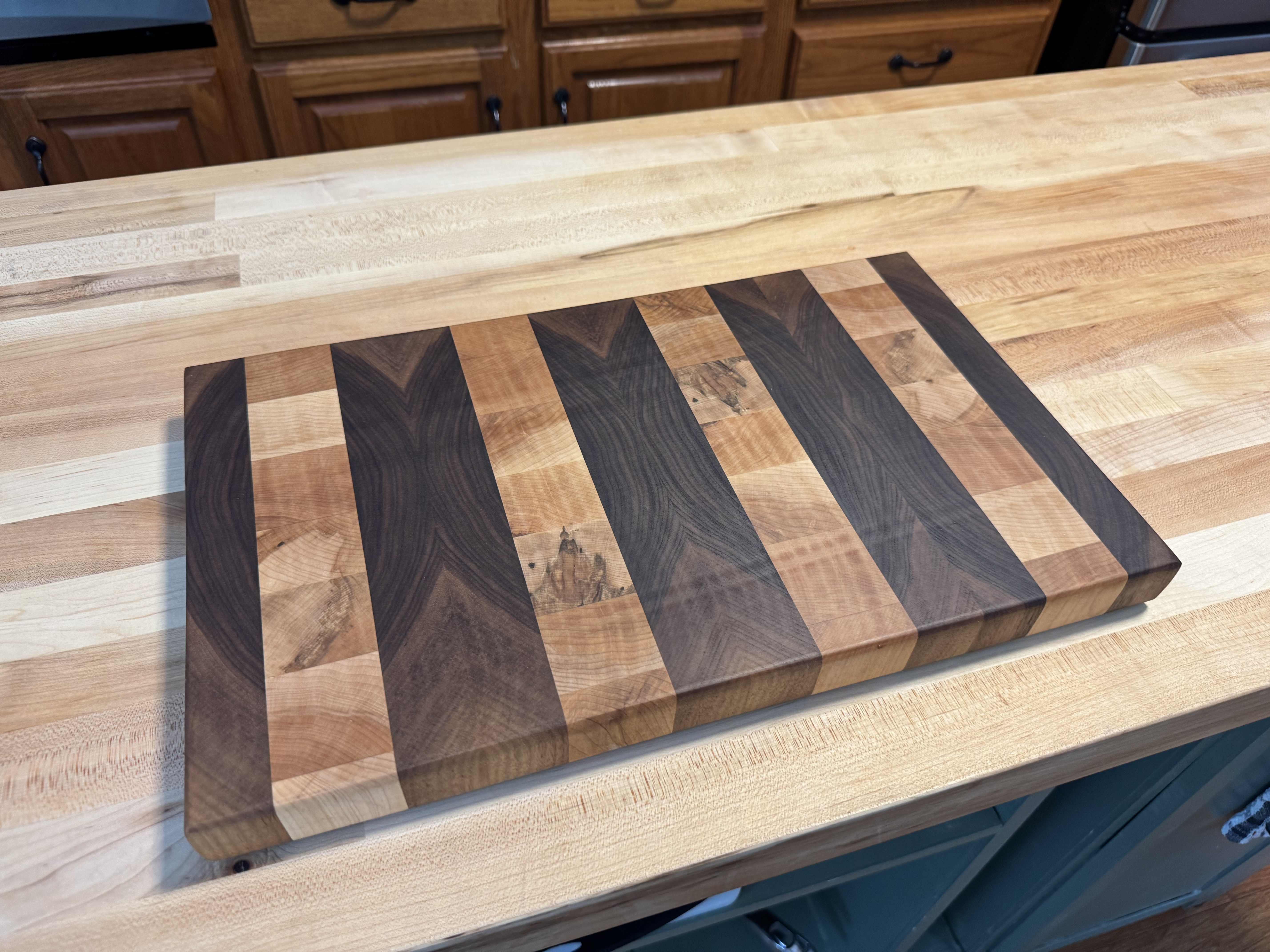End grain cutting board with contrasting hardwood stripes